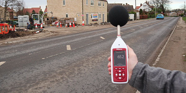 An image showing an Optimus+ Green environmental noise meter being used to measure exposure to environmental noise outdoors